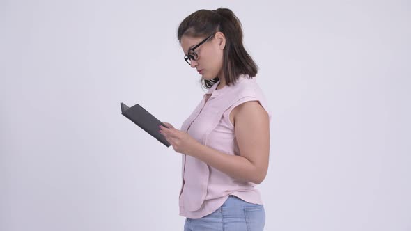 Profile View of Young Asian Businesswoman Reading Book and Being Taken Away alt
