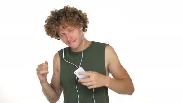 Young Man Enjoying Listening to Favourite Music on Mobile Via Headphones Dancing Smiling Touching alt