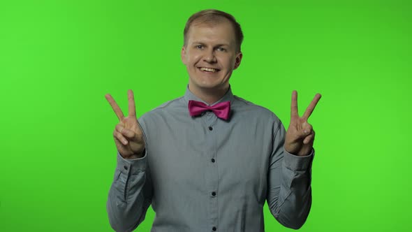 Man Showing Victory Sign, Success and Win, Peace Gesture and Smiling with Kind Optimistic Expression alt