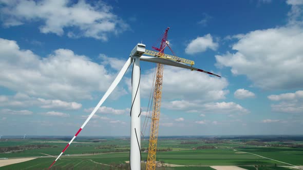 The wind farm during construction, the crane lifts a huge propeller