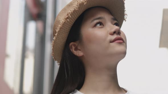 Portrait of young girl traveler walking and looking up around in the old town. alt