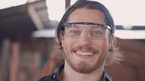 Portrait of Caucasian male carpenter wearing protective glasses
