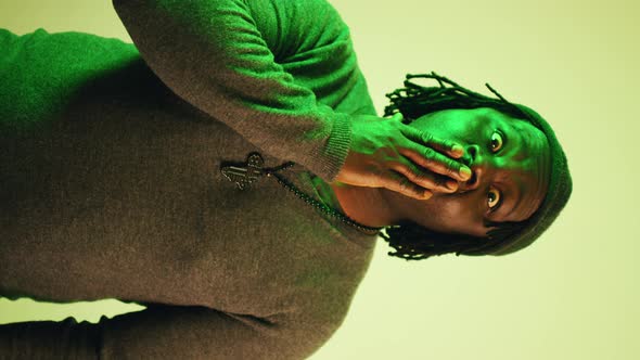 Surprised African Man with Dreadlocks Putting Hand Over His Mouth alt