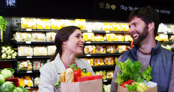 Couple shopping for fruits and vegetables in organic section alt