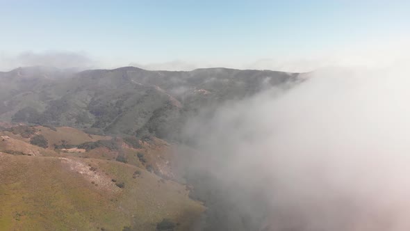 Drone Flies Through Clouds Above Mountains