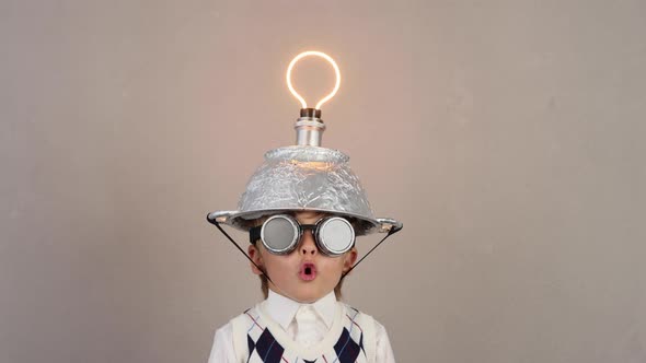 Funny child wearing handmade helmet with lightbulb. Slow motion alt