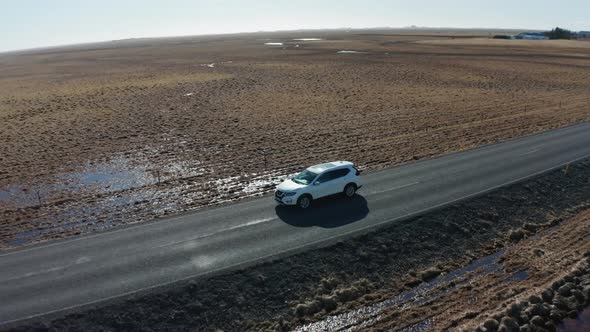 Aerial View of a Moving Car on a Deserted Road in Iceland in Early Spring