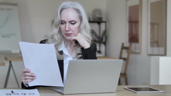 Middle Aged Businesswoman Reading Documents alt
