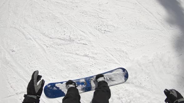 POV of a snowboarder snowboarding downhill at a ski resort. alt