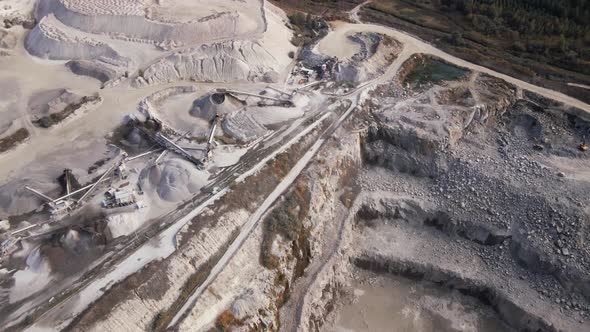 Aerial view of Slope operating granite quarry with mining equipment on ledges alt
