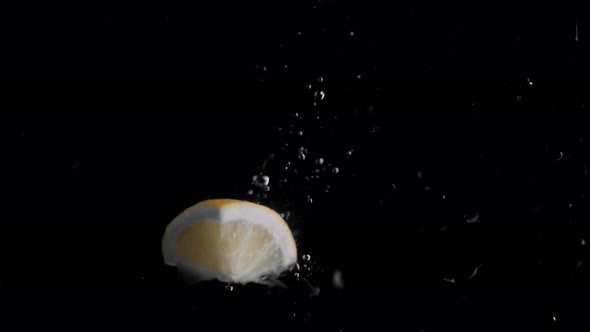 Lemon Piece Falling into Water Super Slowmotion, Black Background, lots of Air Bubbles, 4k240fps alt