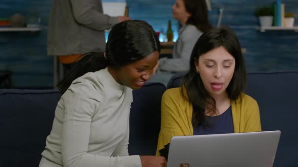 Multiethnic Friends Eating Snacks While Relaxing on Couch Watching at Comedy Video alt