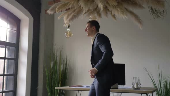 happy man in business suit dancing in office alt