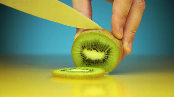 Horizontal Shot of Male Hands Cutting Kiwi Fruits alt