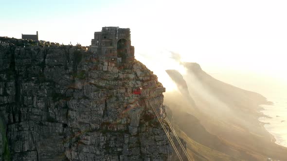 Profile Shot of a Cable Car Going Up a Mountain with a Dramatic Sunset in the Bg