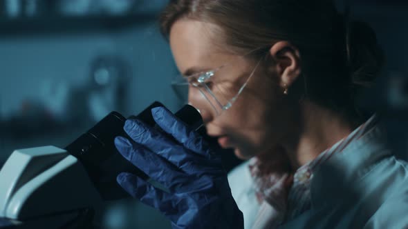 Woman Scientist Is Looking Into Microscope, Biochemical Research. Scientific and Medical Lab alt