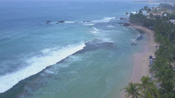 Yellow Sandy Coastline Between Palm Trees and Ocean alt