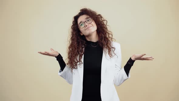 The Smiling Young Woman with Curly Hair Holds Her Hands to the Side and Says Look Like That Smiling alt