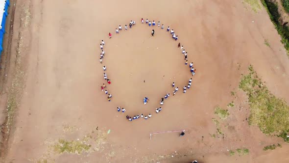African School Playground, Kids Standing in Circle and Playing Game, Aerial View alt