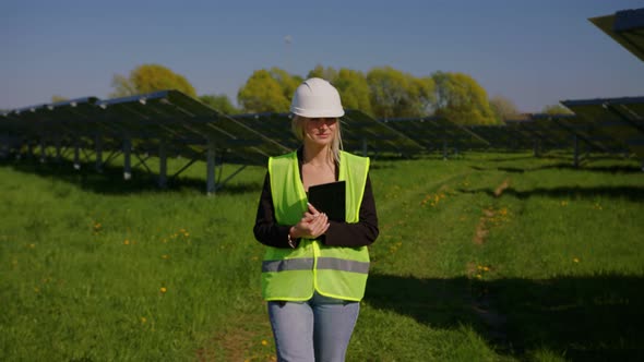 In Solar Park Female Engineer Walking on Eco Field with Installed Groundmounted Panels Outdoor