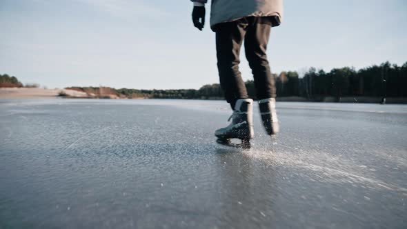 Man Practice Ice Skating on a Clear Frozen Lake on Sunny Day Making Ice Sparkle
