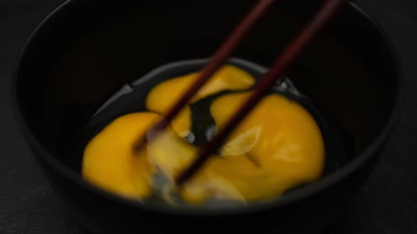 Mixing raw eggs with chopsticks alt
