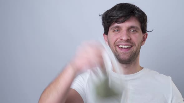 Close-up Portrait of a Man Removes a Respiratory Face Mask During the Quarantine of the COVID-19 alt