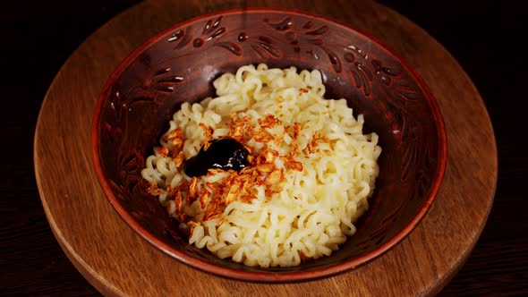 Readymade Instant Noodles with Condiment in Plate on Wooden Board alt