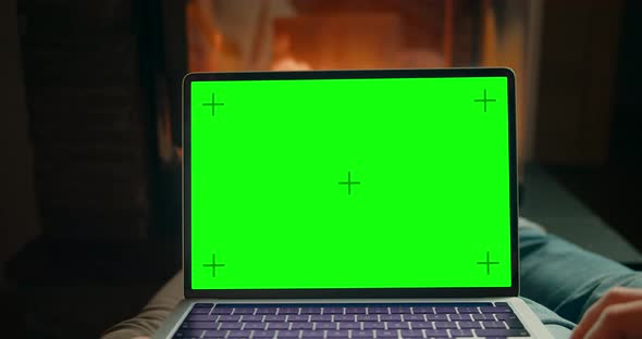 Couple Use Laptop with Chromakey Green Screen at Fireplace Watching Movie Online