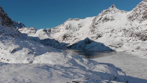 Village called "A" in the Lofoten islands. Frozen lake in the valley filmed with a drone 