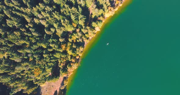 Top Down View Of Turquoise Water With Kayak At Lake Saint Ann In Romania - aerial drone shot alt