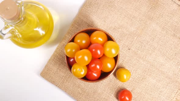 Colorful Cherry Tomato in a Bowl and Olive Oil on Table alt