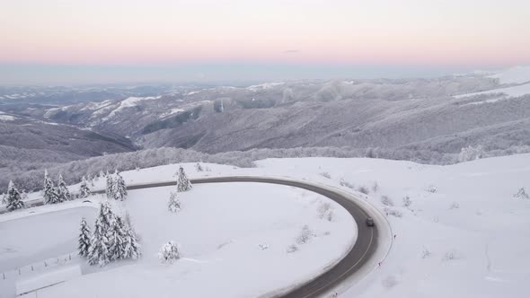 Cars Passing By on Winding Mountain Passage Against Beautiful Winter Landscape alt