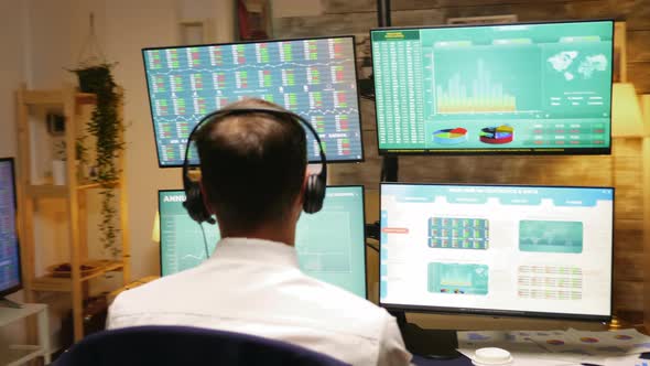 Back Side of Businessman with Headphones in Home Office alt