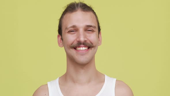 Cool Bright Guy with Mustaches Smiling Over Yellow Background Closeup alt