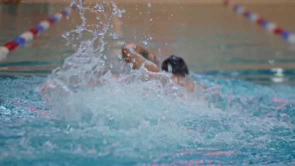 Young Man Swimmer Training in the Water of a Training Pool Indoors alt