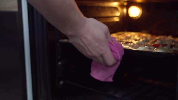 Man Takes Out the Finished Pizza From the Oven at Home alt