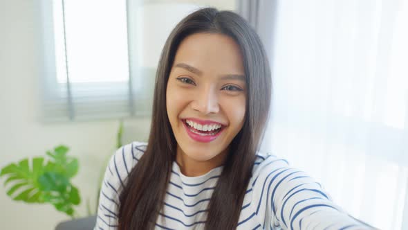 Portrait of Asian beautiful woman sit on sofa in living room at home. alt