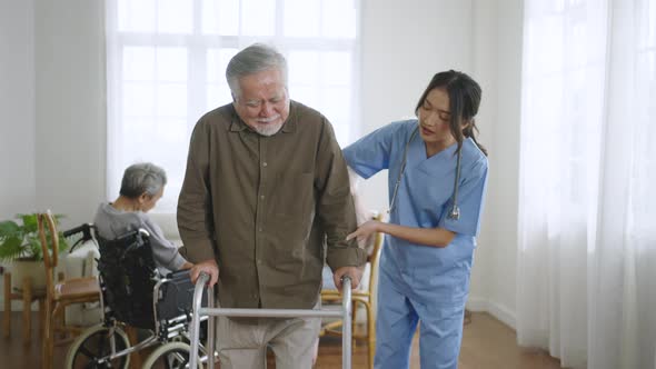 Caretaker helping elderly woman with walking physical therapy