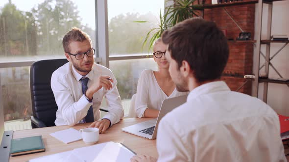 Caucasian Male Boss with Glasses and Light Bristle Sitting at Table with Female Secretary alt