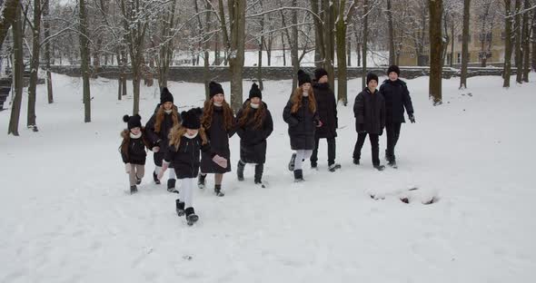 Boys And Girls Walk In A Snowy Couple. Children Play In The Yard