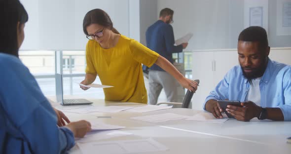 Diverse Businesspeople Working at Large Desk in Coworking Office alt