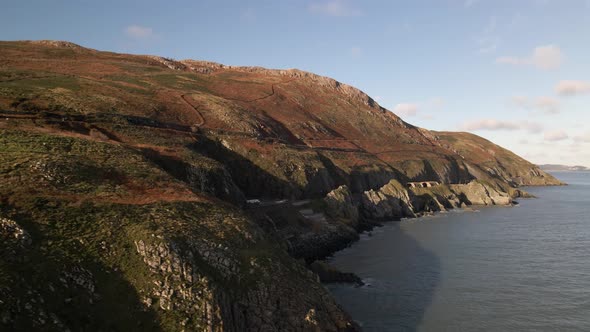Drone shot a steep sea cliff in Ireland on a sunny day. alt