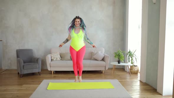Fat Woman in Bright Sportswear Is Jumping Rope Doing Cardio at Home Front View