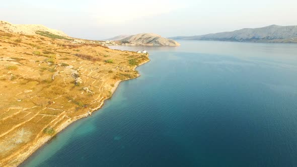 Flying at sunset above barren landscape of Pag island alt