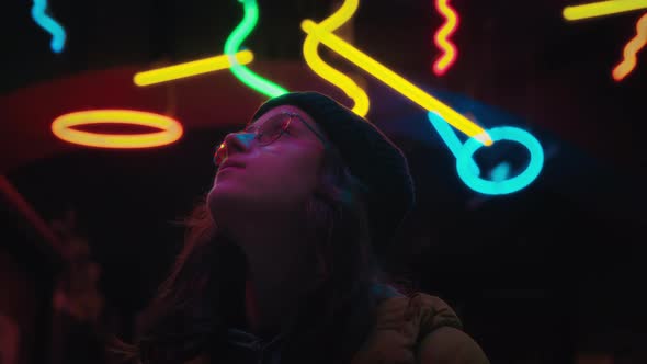 Young Woman Use Phone in Trendy Downtown Neon Set alt