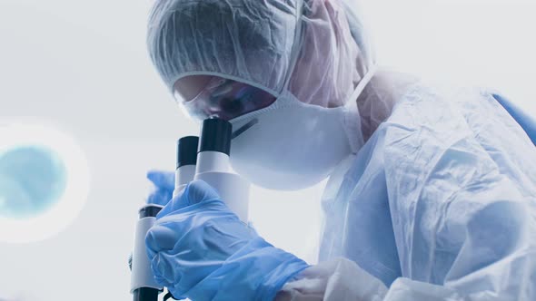 Low Angle Shot of Scientist Woman Looking Down in a Microscope alt