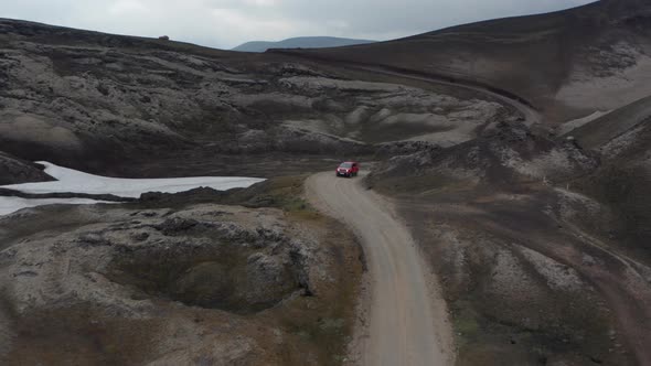 Aerial View 4X4 Car Driving on Winding Road Discovering Wilderness of Iceland Highlands alt