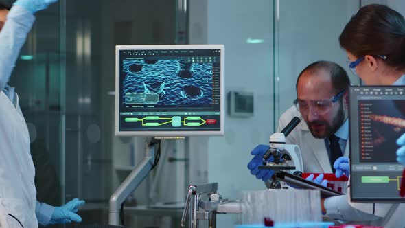 Team of Scientists Doing Biological Researches Under Microscope alt