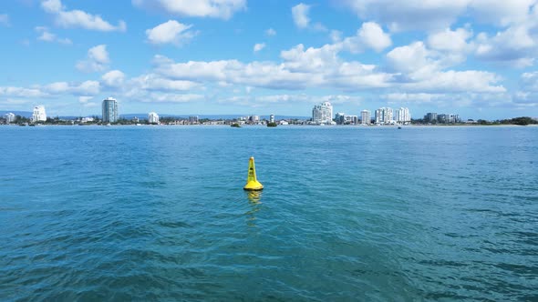 Revealing a yellow marine speed limit marker buoy sits anchored in calm waters of a major waterway z alt